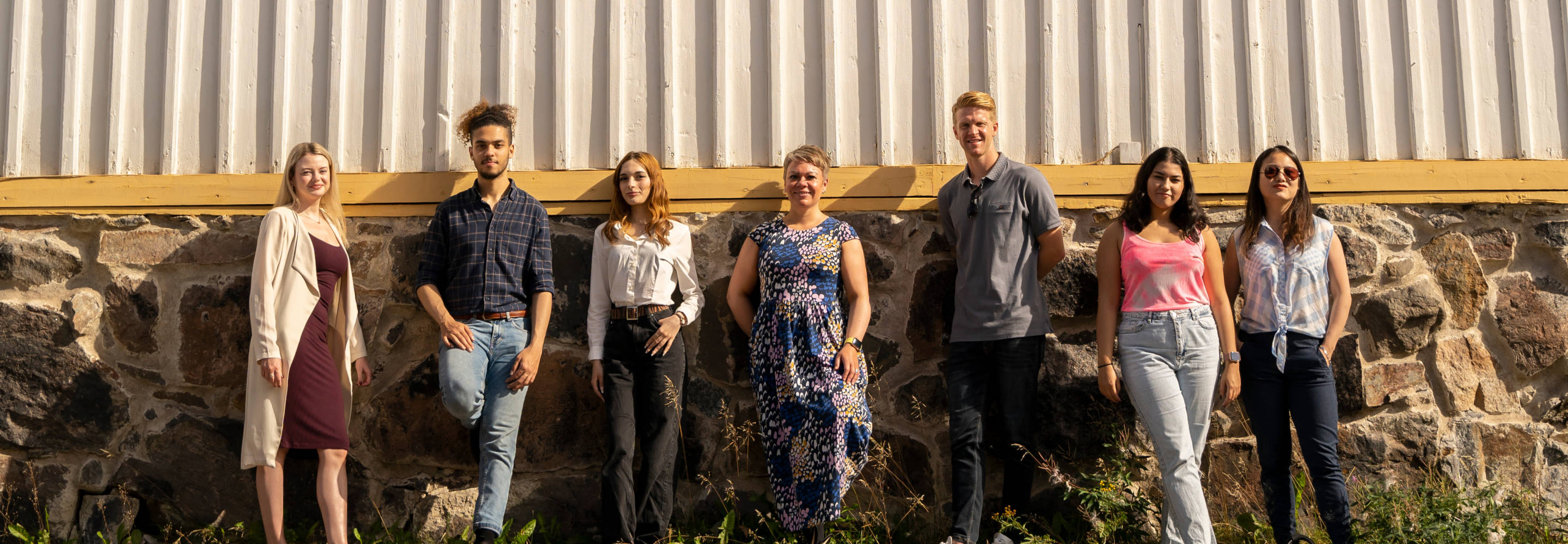 Diverse group of students posing for the camera in the old wooden house district of Kokkola