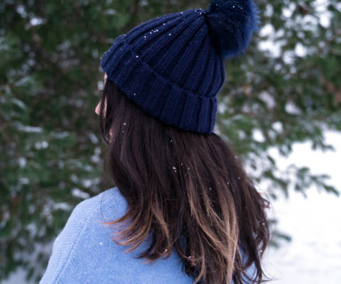 Female student wearing the Centria beanie with tassel. The picture is taken from the side to showcase the tassel.