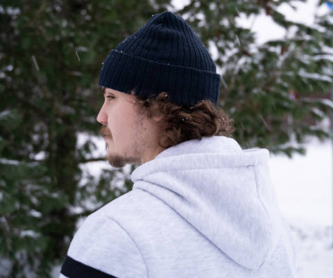 Male student wearing the Centria beanie. The picture is taken behind his back to show the back of the beanie.