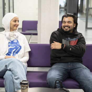 Two students sitting on a couch on campus
