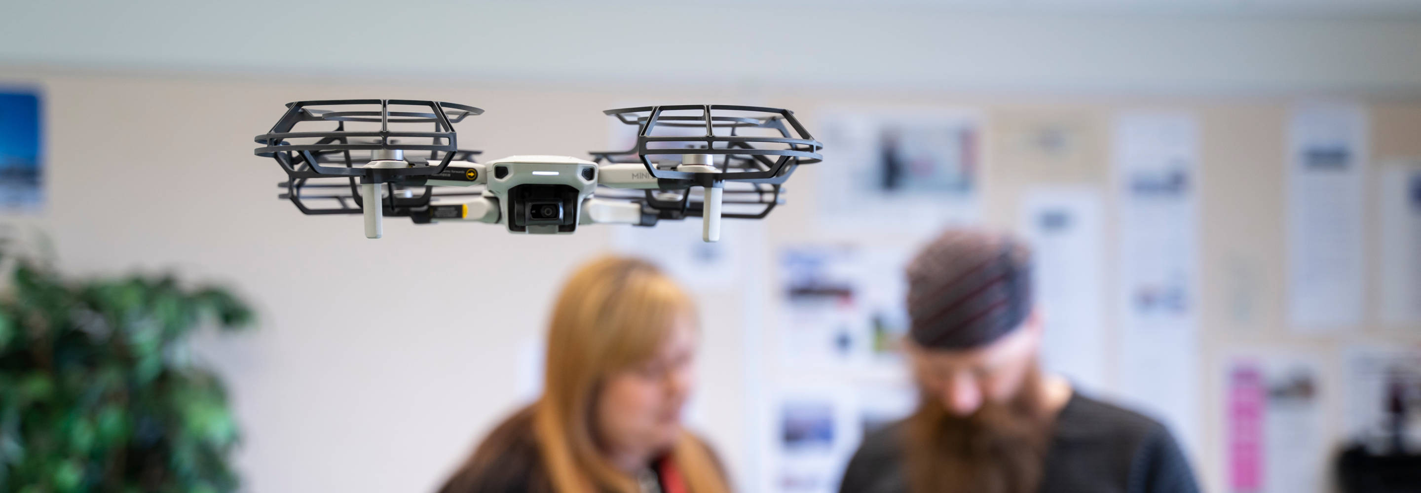 Ilmassa lentävä drone, jota ohjaa kaksi TKI-asiantuntijaa