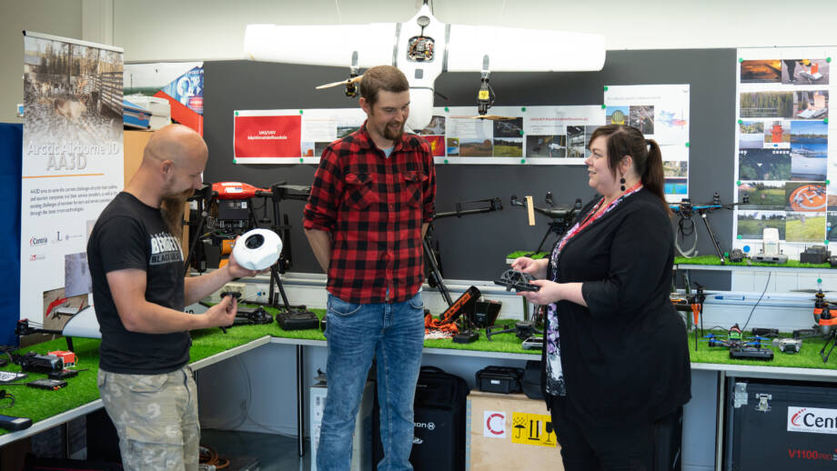 Kolme henkilöä Centria Drone Labissa tutustumassa laitteisiin.