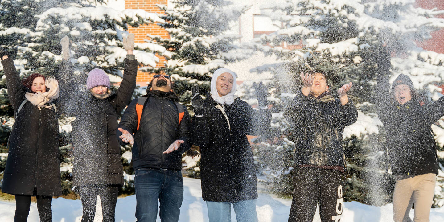 Ryhmä opiskelijoita kuvattuna Talonpojankadun kampuksen pihalla talviaikaan.