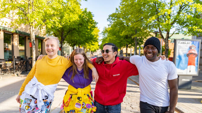 A diverse group of students walking together and laughing in the Kokkola centre