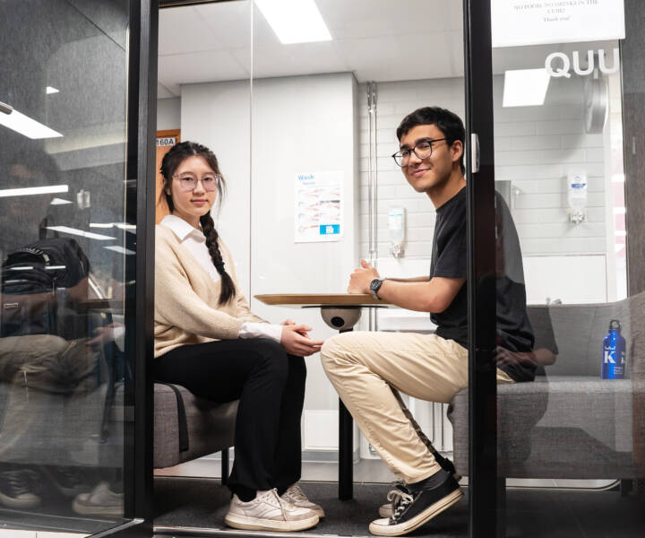 Two bachelor's students pictured on Talonpojankatu campus in a meeting cube.