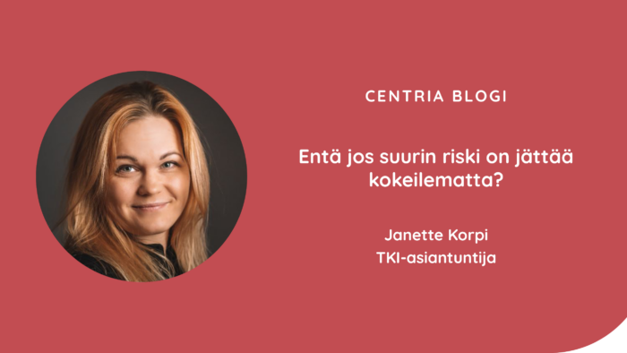 Kuvassa Janette Korpi poseeraa kameralle, taustalla sumea tausta. Kuvassa myös blogin otsikko.